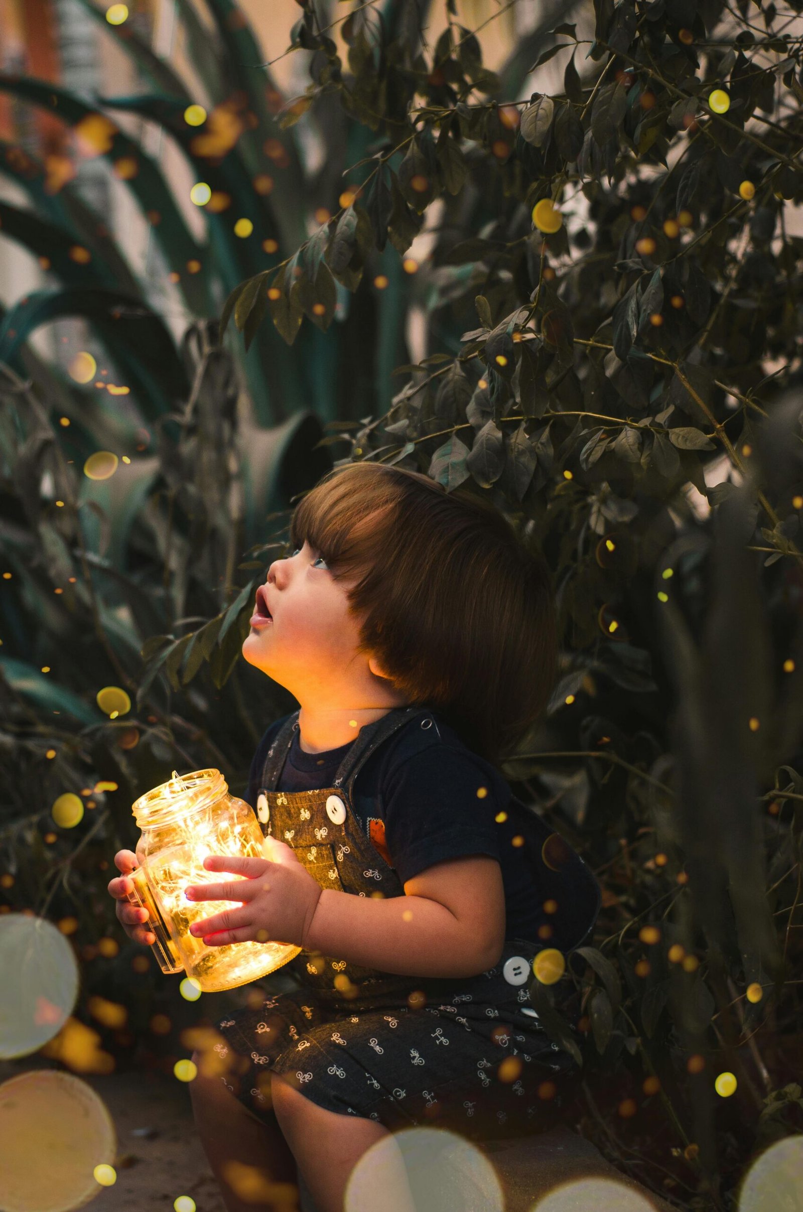 A young child gazes in wonder while holding a jar of lights in a magical forest setting, capturing innocence and curiosity.