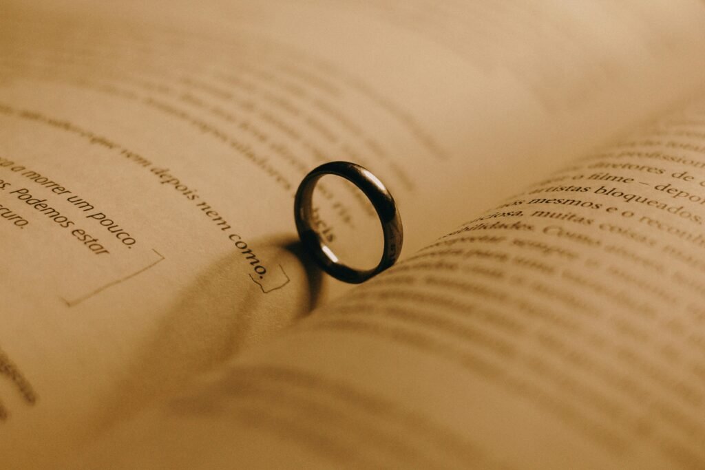Engagement ring casting heart-shaped shadow on book page, symbolizing love.
